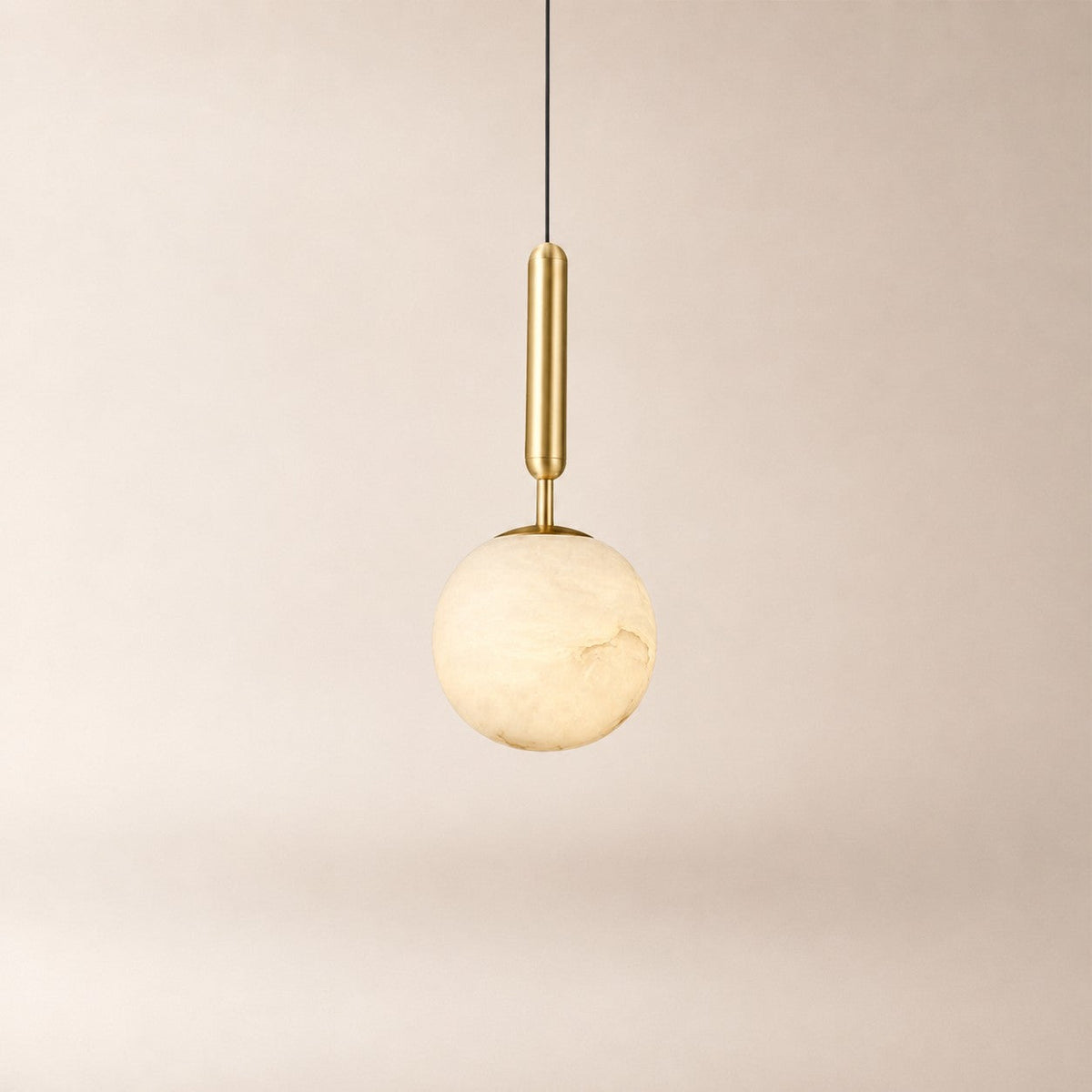 Nuvlight Velriq pendant light with a spherical natural alabaster shade and warm brass accents